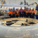 weir team gathered around machinery